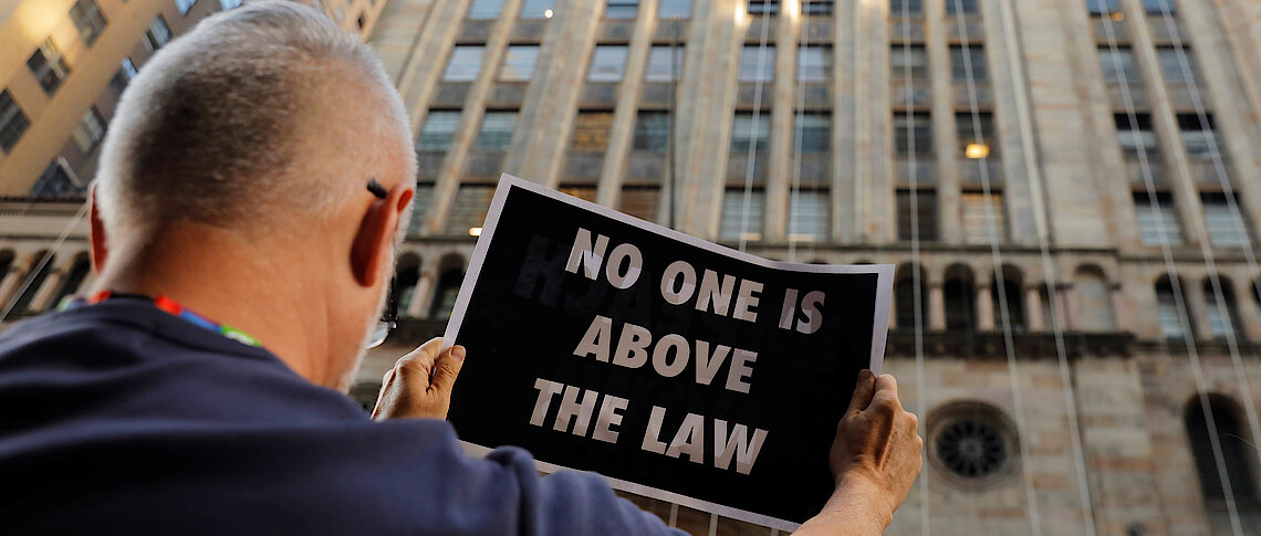 Demonstrators hold protest signs as part of a demonstration in support of impeachment hearings in New York Reuters