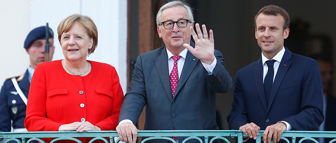 German Chancellor Angela Merkel and French President Emmanuel Macron welcome European Commission President Jean-Claude Juncker  Reuters